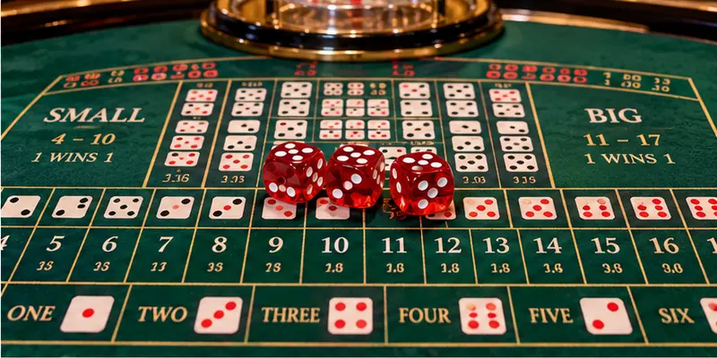 A casino dealer presenting three red dice beneath a transparent shaker on a Sic Bo table.